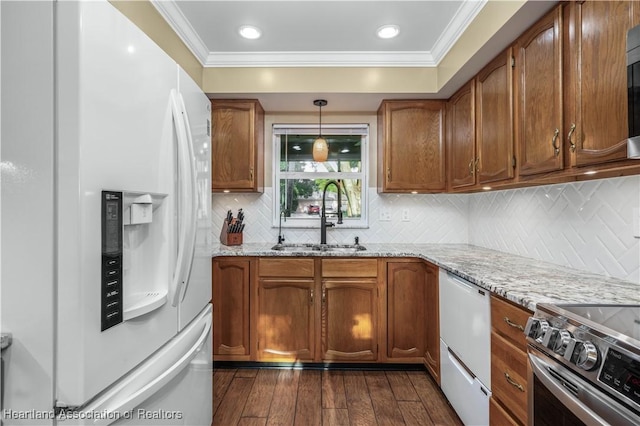 kitchen with sink, hanging light fixtures, stainless steel appliances, light stone counters, and decorative backsplash