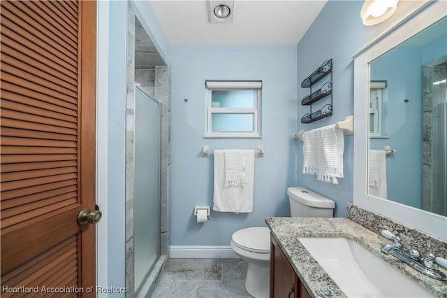 bathroom featuring vanity, toilet, and a shower with door