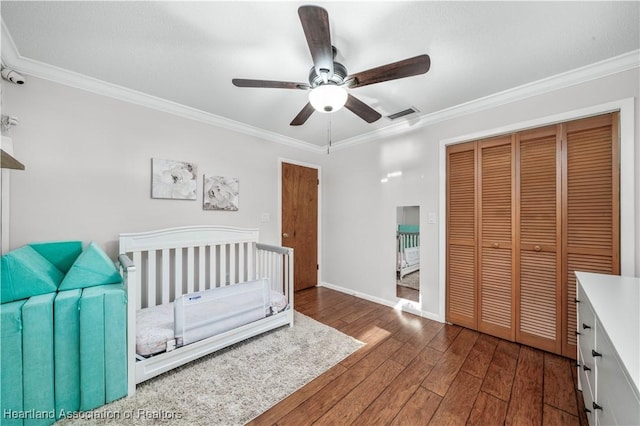 bedroom with dark hardwood / wood-style flooring, a closet, ceiling fan, and crown molding