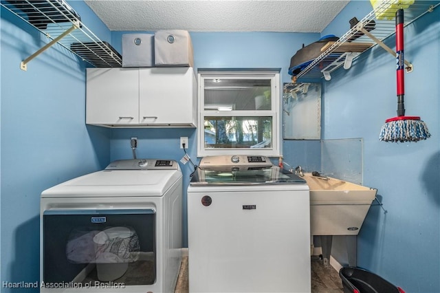 laundry room featuring sink, cabinets, separate washer and dryer, hardwood / wood-style floors, and a textured ceiling