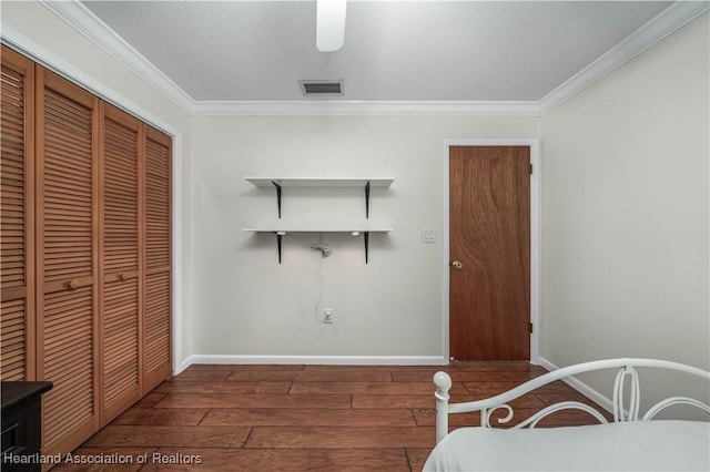 bedroom featuring ceiling fan, dark hardwood / wood-style flooring, crown molding, a textured ceiling, and a closet