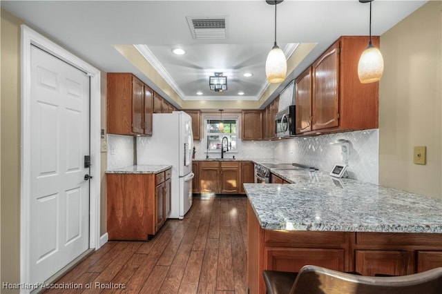 kitchen with stainless steel appliances, tasteful backsplash, dark hardwood / wood-style flooring, kitchen peninsula, and decorative light fixtures