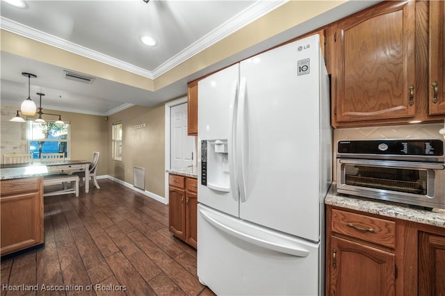 kitchen with decorative backsplash, crown molding, dark wood-type flooring, hanging light fixtures, and white fridge with ice dispenser