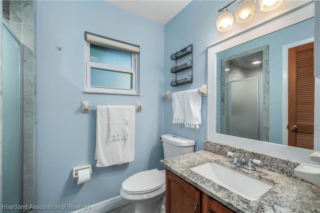 bathroom featuring vanity, toilet, and a shower with shower door