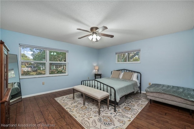 bedroom featuring a textured ceiling, dark hardwood / wood-style flooring, and ceiling fan