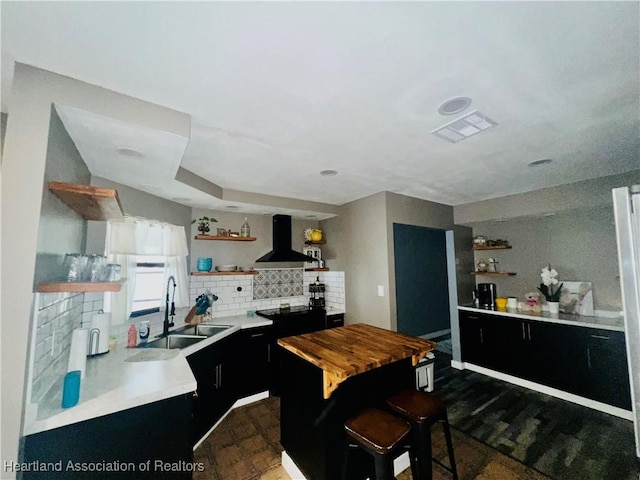 300 Whatley Blvd, Sebring, FL 33870 - kitchen with open shelves, wall chimney exhaust hood, a sink, dark cabinets, and tasteful backsplash
