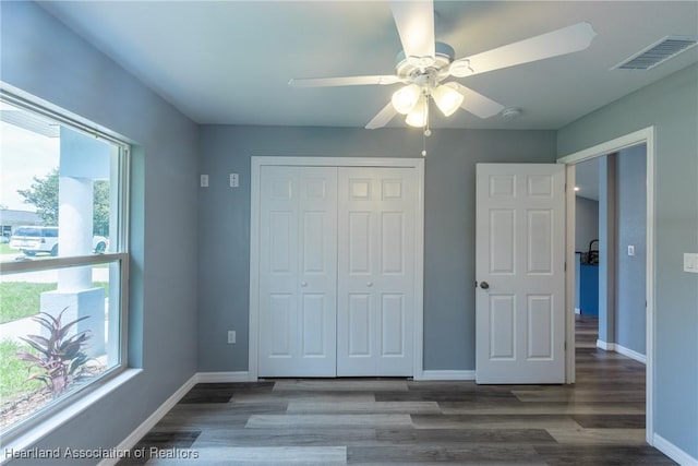 unfurnished bedroom featuring a closet, ceiling fan, and dark hardwood / wood-style floors