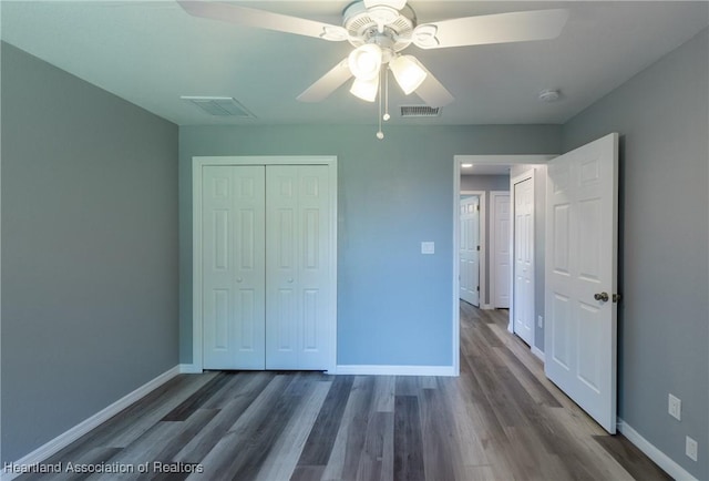 unfurnished bedroom with a closet, ceiling fan, and dark wood-type flooring