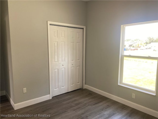 3900 Santiago St, Sebring, FL 33872 - unfurnished bedroom featuring a closet, dark wood-type flooring, and multiple windows