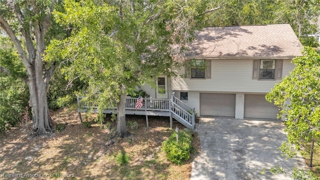 5324 Lafayette Ave, Sebring, FL 33875 - view of front of home with roof with shingles, a wooden deck, an attached garage, and driveway