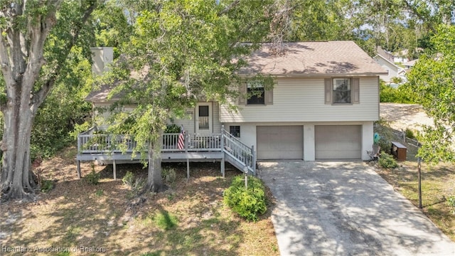 5324 Lafayette Ave, Sebring, FL 33875 - split level home featuring a chimney, roof with shingles, a deck, concrete driveway, and an attached garage