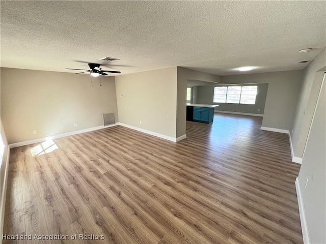 unfurnished room with ceiling fan, dark wood-type flooring, and a textured ceiling