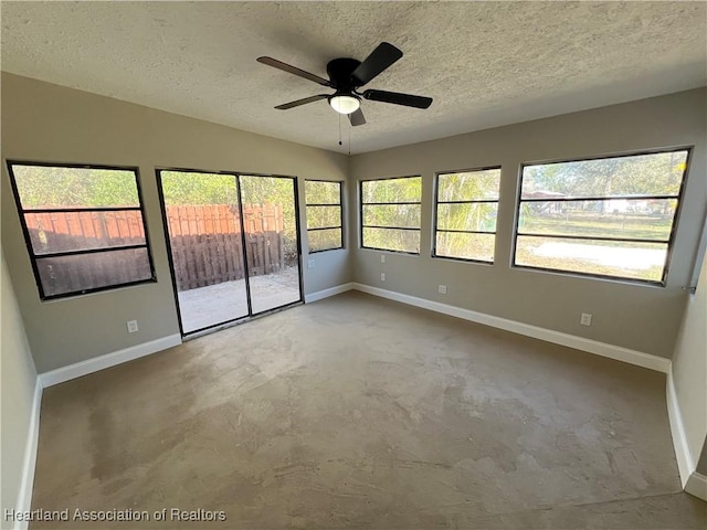 interior space featuring concrete flooring, lofted ceiling, ceiling fan, and a textured ceiling