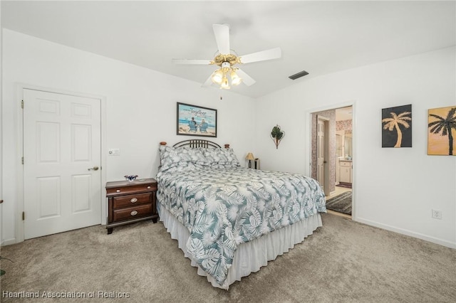 carpeted bedroom with ceiling fan and ensuite bath