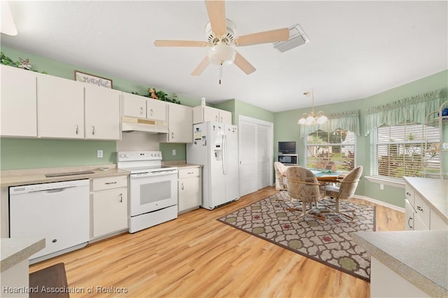 kitchen with hanging light fixtures, white appliances, white cabinets, and light wood-type flooring