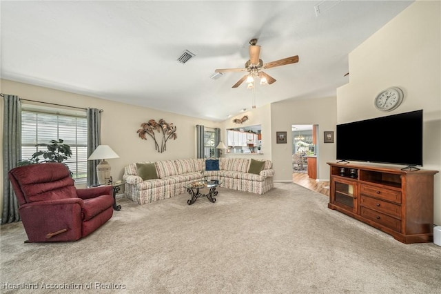 carpeted living room with lofted ceiling and ceiling fan