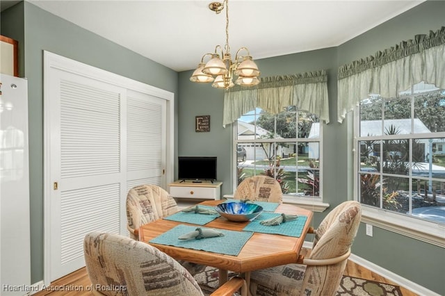 dining space featuring hardwood / wood-style flooring and a notable chandelier