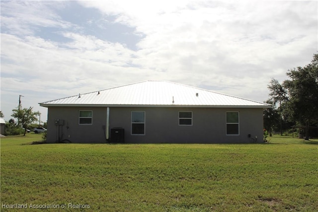 5195 Greenfields Run, Zolfo Springs, FL 33890 - back of property featuring stucco siding, a lawn, and a metal roof