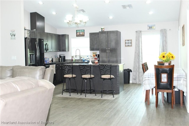5195 Greenfields Run, Zolfo Springs, FL 33890 - kitchen featuring refrigerator with ice dispenser, a chandelier, a breakfast bar area, open floor plan, and light wood finished floors