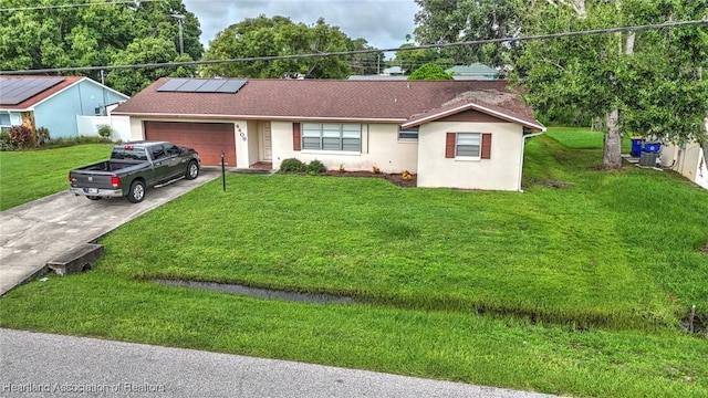 ranch-style home featuring a front yard, solar panels, and a garage