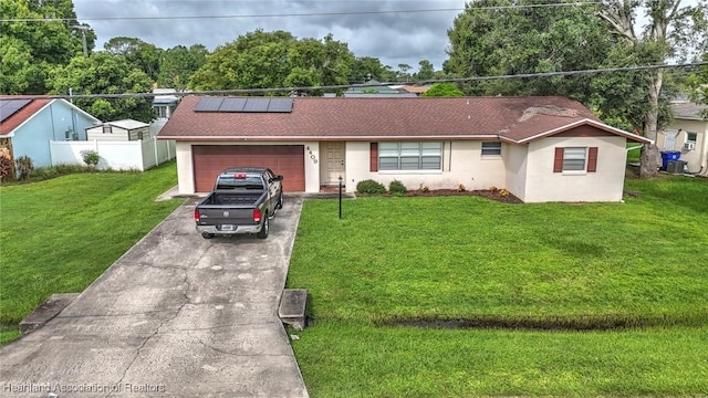 single story home featuring a front lawn, a garage, and solar panels