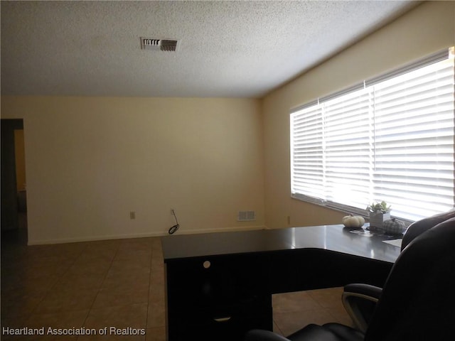 office area with tile patterned flooring and a textured ceiling