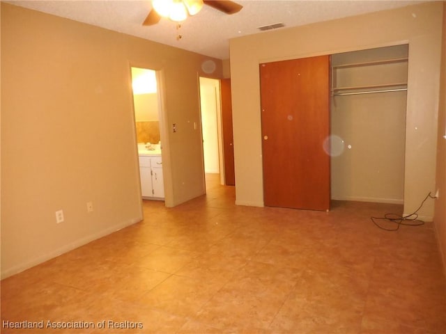 unfurnished bedroom with ceiling fan and a closet