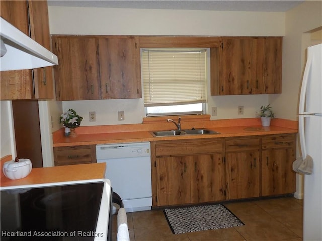 kitchen featuring sink, dark tile patterned floors, and white appliances