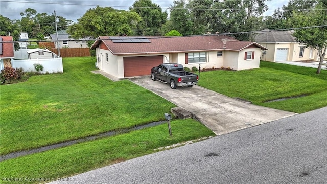 ranch-style home with a front lawn, a garage, and solar panels