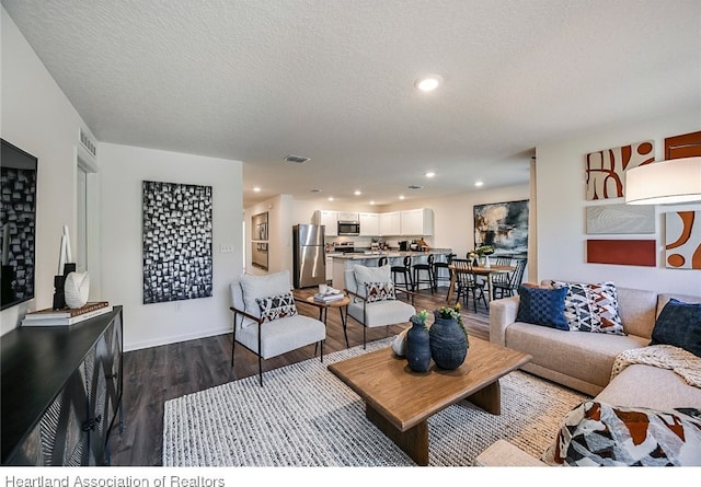 living room with dark hardwood / wood-style floors and a textured ceiling