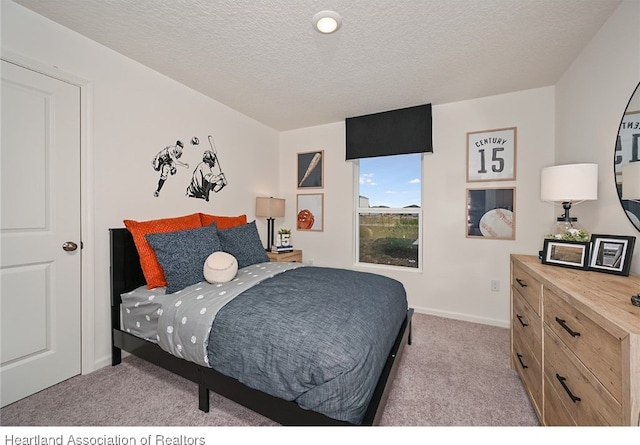 bedroom featuring light carpet and a textured ceiling