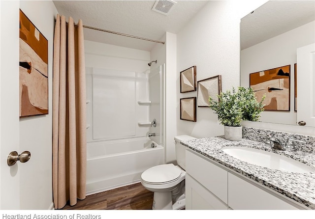 full bathroom featuring vanity, shower / bath combination with curtain, toilet, a textured ceiling, and wood-type flooring