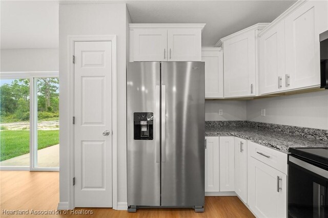 9131 Canter Path, Sebring, FL 33875 - kitchen with stainless steel appliances, white cabinetry, light wood-style floors, and light stone countertops