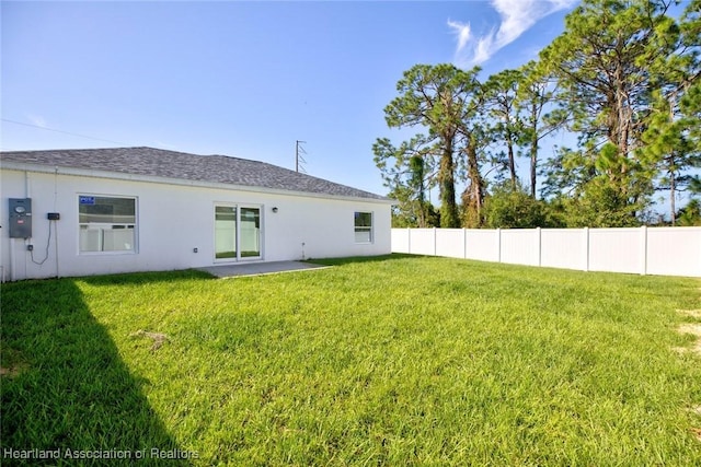 rear view of house with a yard and a patio