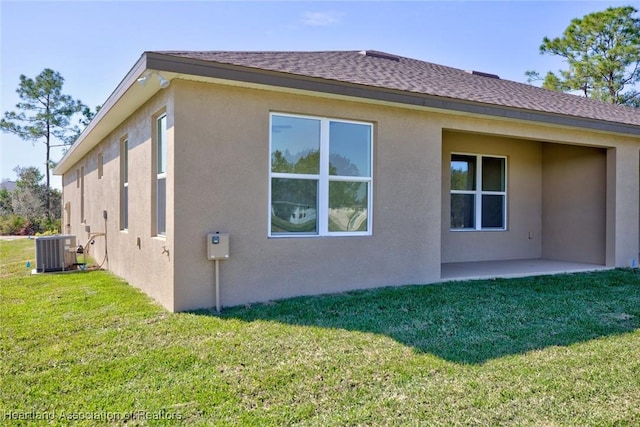 view of side of home featuring a patio, a lawn, and central air condition unit