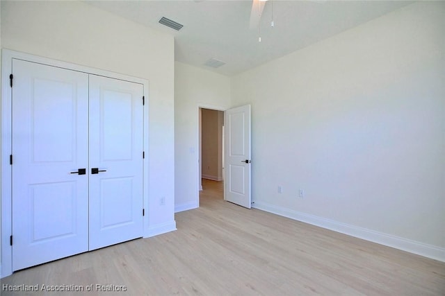 unfurnished bedroom with ceiling fan, a closet, and light hardwood / wood-style flooring