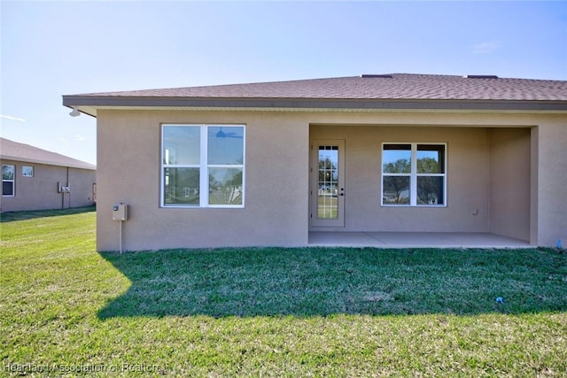 back of house with a lawn and a patio area