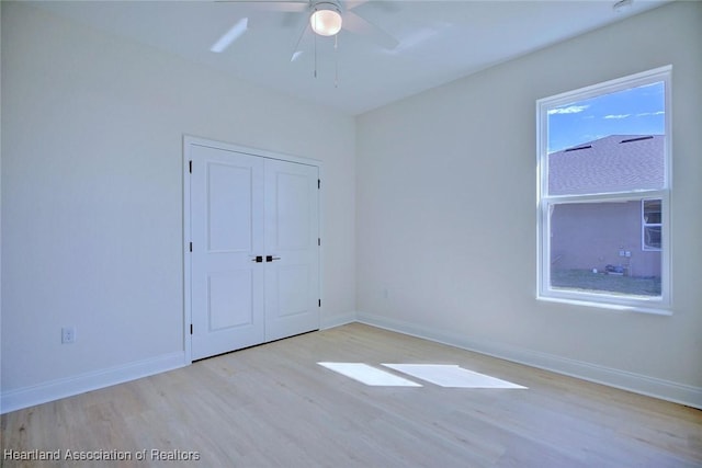 unfurnished bedroom featuring ceiling fan, light hardwood / wood-style floors, and a closet