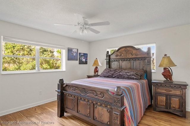 bedroom featuring ceiling fan, a textured ceiling, and light wood-type flooring