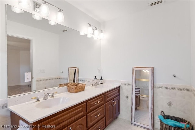 bathroom featuring vanity, tile walls, tile patterned floors, and toilet