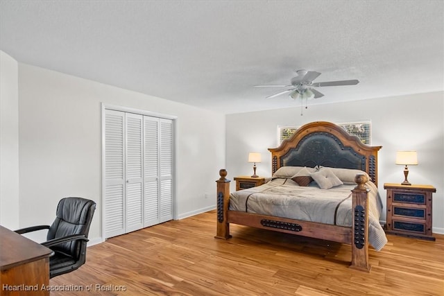 bedroom with ceiling fan, light hardwood / wood-style floors, a closet, and a textured ceiling