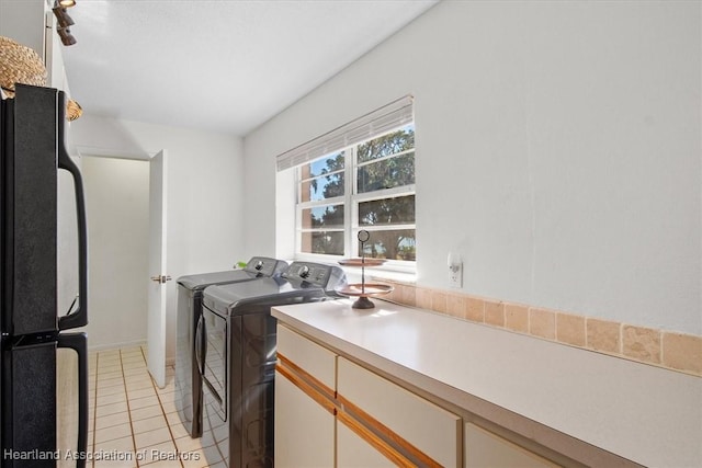 laundry room with washing machine and clothes dryer and light tile patterned floors
