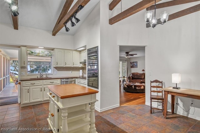 kitchen with sink, ceiling fan with notable chandelier, beam ceiling, decorative light fixtures, and stainless steel dishwasher