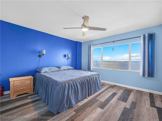 2131 Lakeview Dr Unit 1008, Sebring, FL 33870 - bedroom featuring wood finished floors, a ceiling fan, a textured ceiling, and a water view