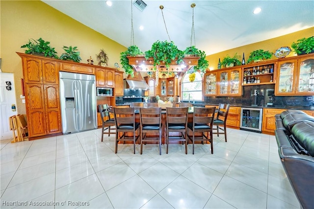14630 Luray Rd, Southwest Ranches, FL 33330 - dining space with beverage cooler, wet bar, recessed lighting, light tile patterned floors, and high vaulted ceiling