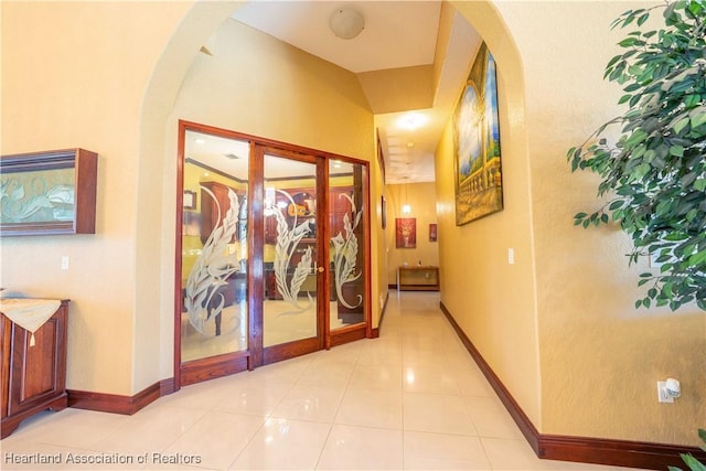 14630 Luray Rd, Southwest Ranches, FL 33330 - hall with arched walkways, french doors, baseboards, and light tile patterned floors
