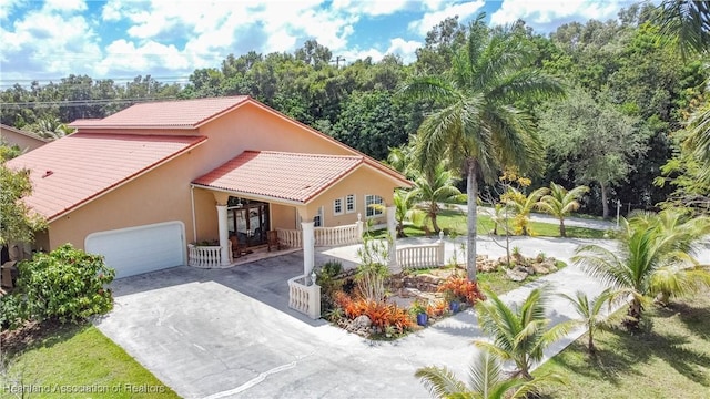 14630 Luray Rd, Southwest Ranches, FL 33330 - mediterranean / spanish house with a tiled roof, concrete driveway, stucco siding, an attached garage, and a porch