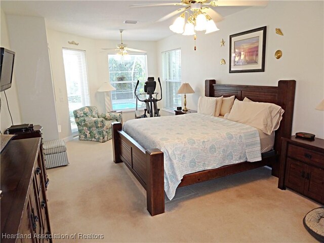 carpeted bedroom with ceiling fan and multiple windows