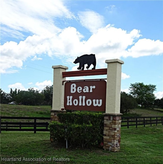 community / neighborhood sign featuring a lawn and a rural view