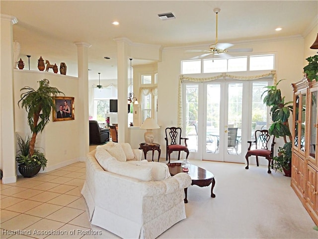 tiled living room with ceiling fan, ornate columns, ornamental molding, and french doors